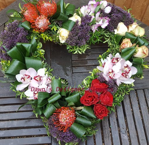 Heart tribute in lilac,orange and cream, from orchids,roses,trachelium